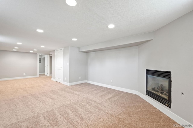 335 N 11th Ave, Brighton, CO 80601 - finished below grade area featuring a glass covered fireplace, light carpet, recessed lighting, baseboards, and a textured ceiling