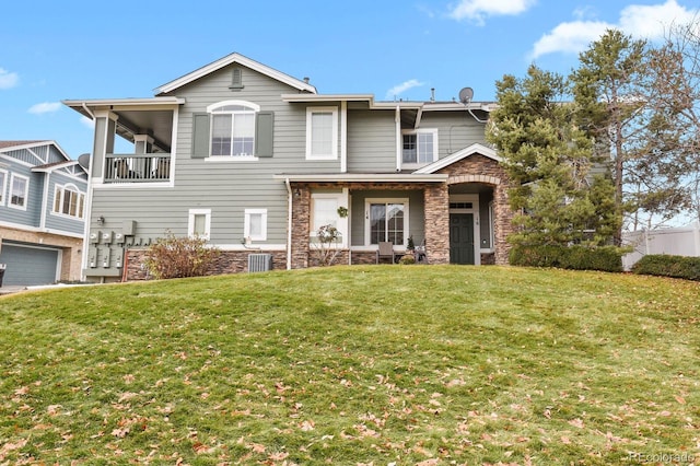 view of front of house with a balcony, central AC, and a front lawn