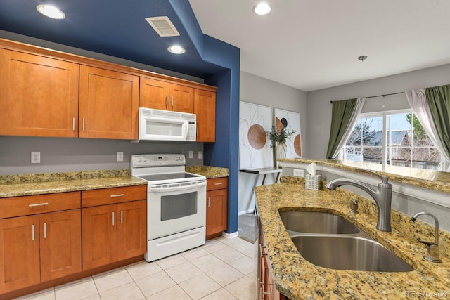 kitchen featuring light stone counters, sink, light tile patterned floors, and white appliances