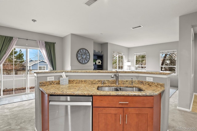 kitchen featuring dishwasher, sink, light carpet, and a wealth of natural light