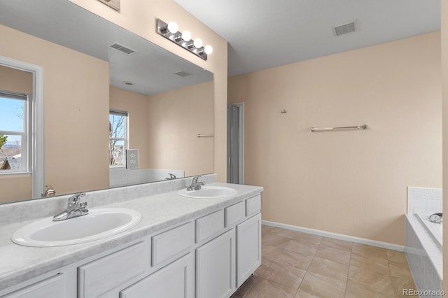 bathroom with tile patterned floors, tiled bath, and vanity