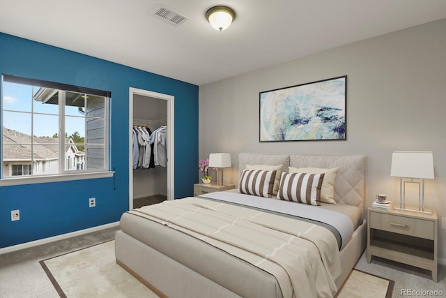 carpeted bedroom featuring a walk in closet and a closet