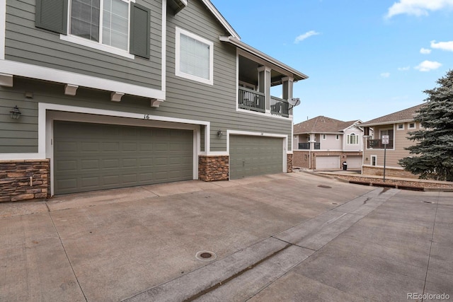 view of side of property featuring a balcony and a garage