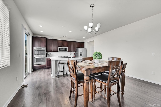 dining room featuring light hardwood / wood-style flooring, an inviting chandelier, and sink