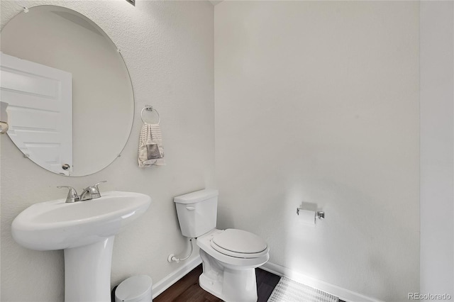 bathroom featuring wood-type flooring and toilet