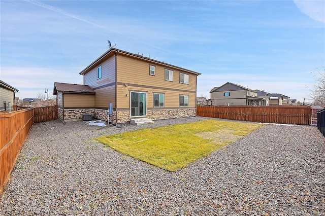 rear view of house with a lawn and cooling unit