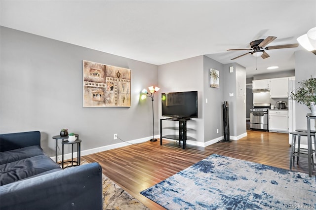 living room with ceiling fan and dark hardwood / wood-style flooring