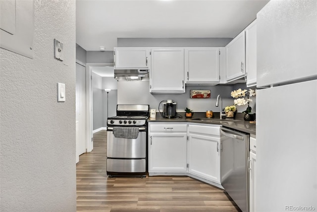 kitchen with sink, light wood-type flooring, white cabinets, and appliances with stainless steel finishes