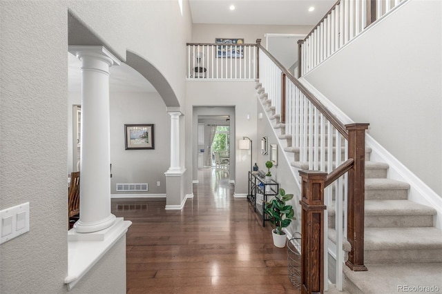 14258 Greenfield Loop, Parker, CO 80134 - entryway featuring ornate columns, hardwood / wood-style floors, arched walkways, recessed lighting, and stairway