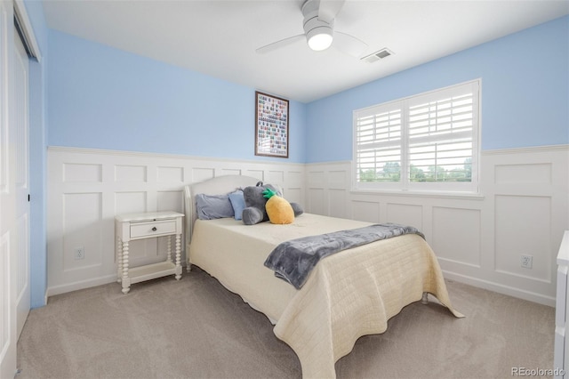 14258 Greenfield Loop, Parker, CO 80134 - bedroom featuring light colored carpet, a decorative wall, wainscoting, and ceiling fan