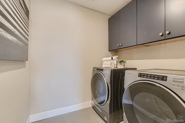 clothes washing area featuring separate washer and dryer, cabinets, and light tile patterned flooring