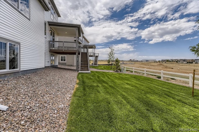 view of yard with a wooden deck and a rural view