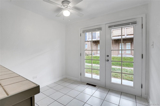 doorway to outside with ceiling fan, french doors, and light tile patterned flooring