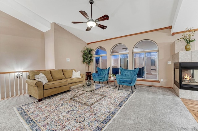 living area with a tile fireplace, a ceiling fan, and lofted ceiling