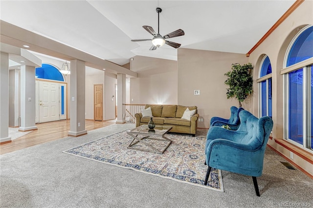 carpeted living room featuring baseboards, visible vents, a ceiling fan, and lofted ceiling