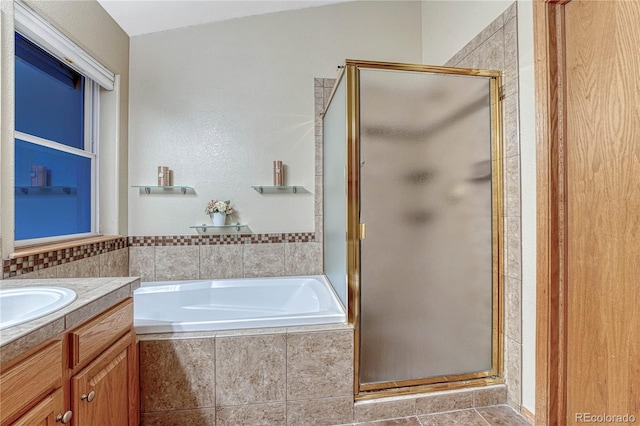 full bathroom featuring vanity, a shower stall, and a bath