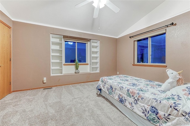 carpeted bedroom with vaulted ceiling, crown molding, visible vents, and ceiling fan