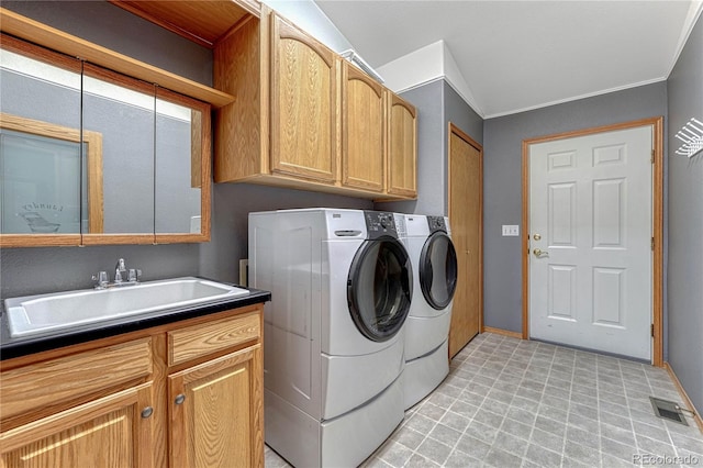 clothes washing area with visible vents, light floors, washer and dryer, cabinet space, and a sink