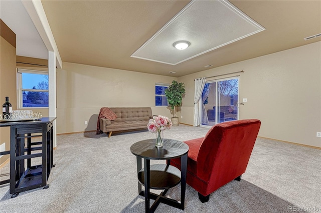 carpeted living area with baseboards and visible vents