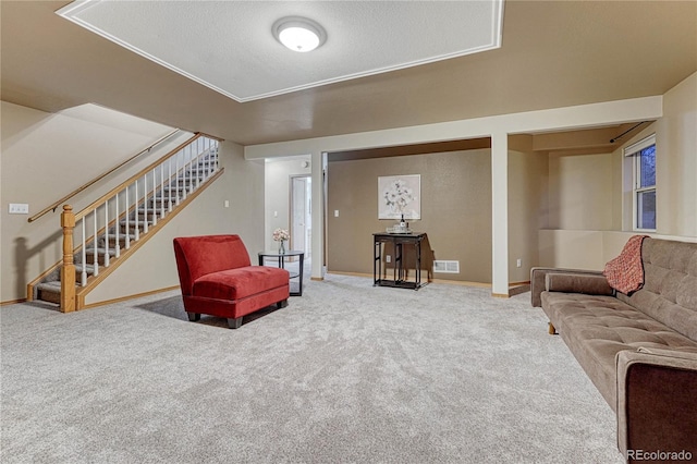 living area with visible vents, carpet flooring, stairway, and baseboards