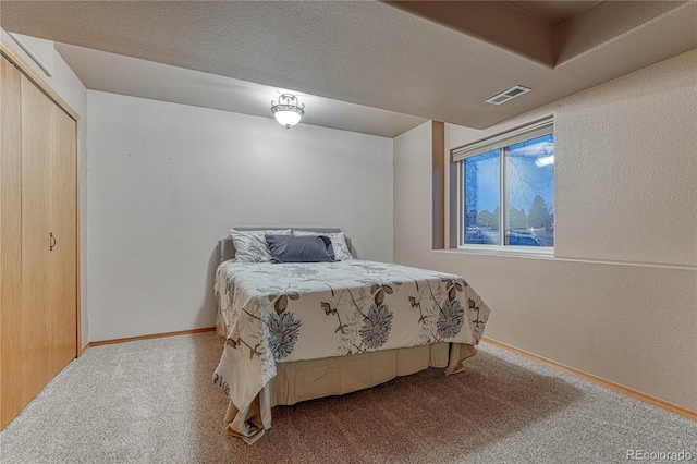 carpeted bedroom featuring visible vents, baseboards, a textured ceiling, and a textured wall