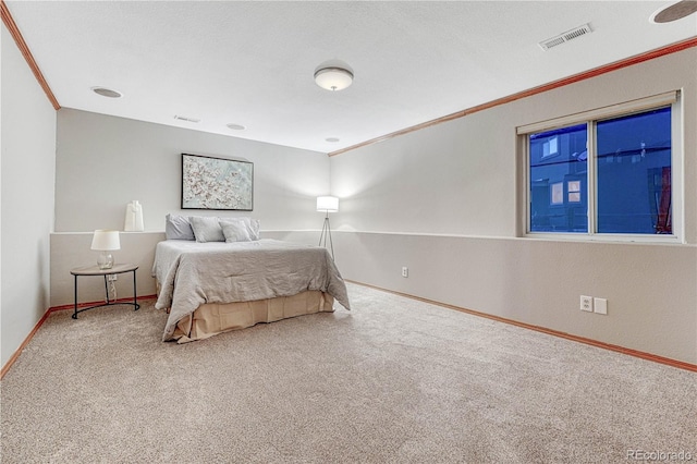 bedroom with carpet flooring, baseboards, visible vents, and crown molding