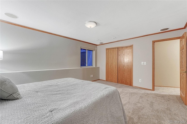 bedroom with a closet, baseboards, crown molding, and carpet