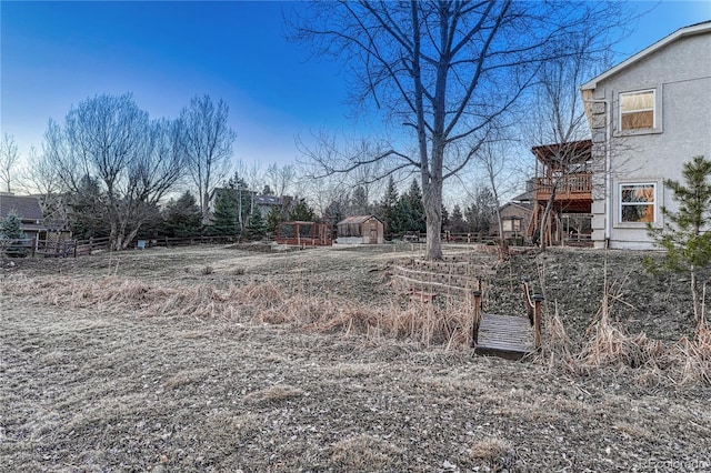 view of yard featuring fence, an outbuilding, and a shed