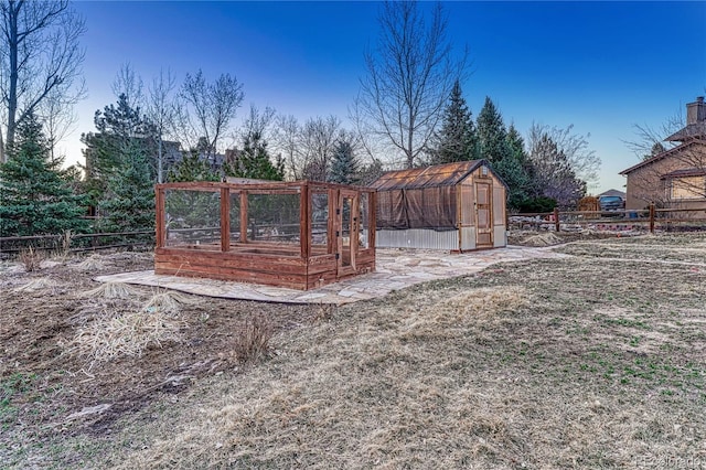 view of yard with an outbuilding, a garden, fence, and an exterior structure