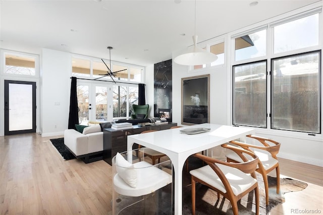 dining area with french doors, an inviting chandelier, and light hardwood / wood-style floors