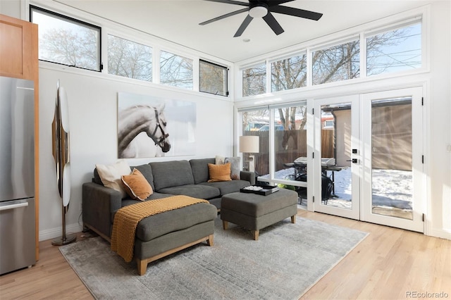 sunroom / solarium featuring a healthy amount of sunlight, ceiling fan, and french doors