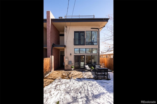 snow covered house with a patio area