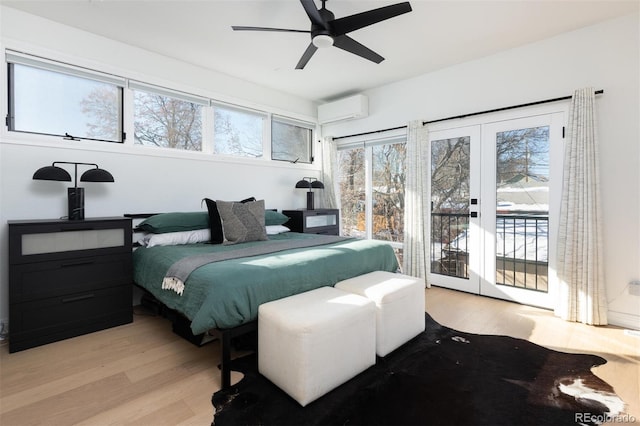 bedroom with light hardwood / wood-style flooring, access to outside, ceiling fan, a wall unit AC, and french doors