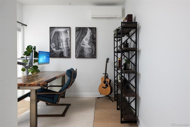 office space with a wall mounted air conditioner and light wood-type flooring