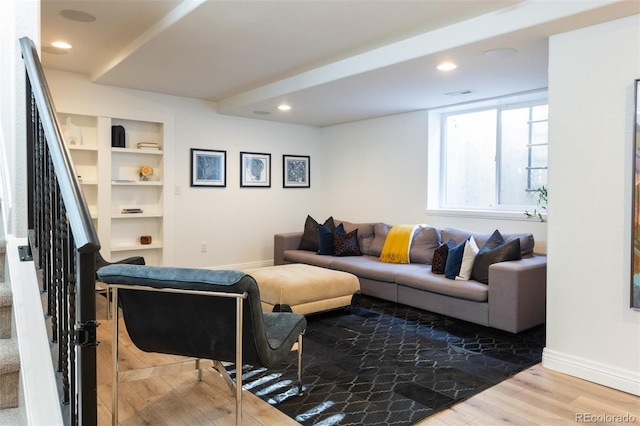 living room featuring wood-type flooring and built in features