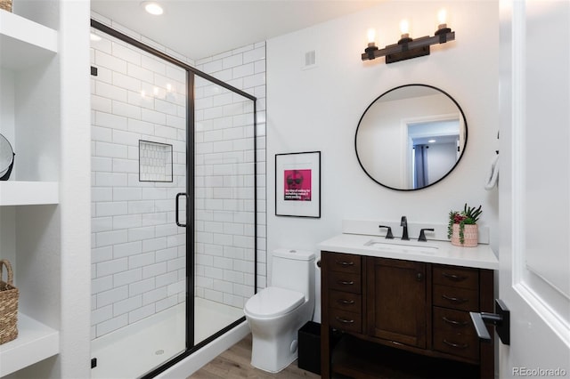 bathroom featuring vanity, toilet, a shower with door, and hardwood / wood-style floors