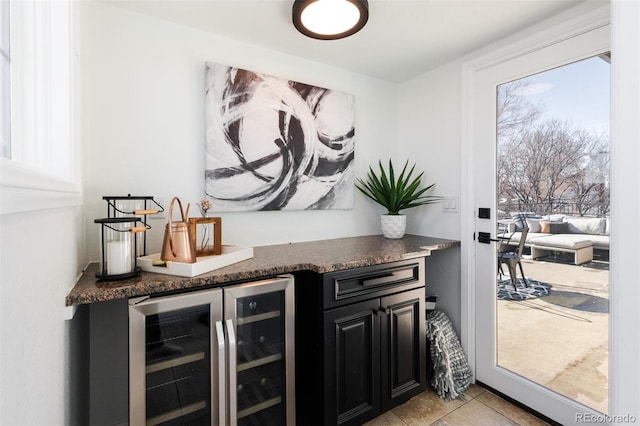 bar featuring light tile patterned floors, wine cooler, and dark stone counters