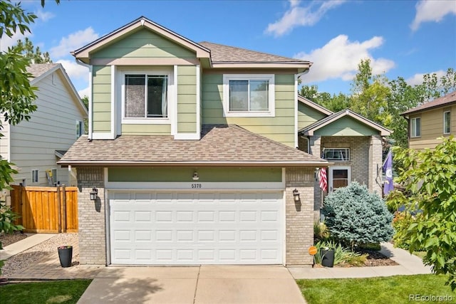 5370 S Gray St, Littleton, CO 80123 - view of front of house featuring brick siding, roof with shingles, driveway, and a garage