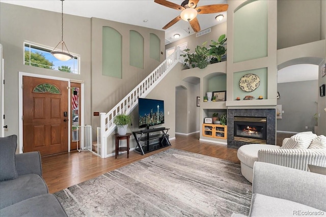 5370 S Gray St, Littleton, CO 80123 - living room featuring a towering ceiling, ceiling fan, wood finished floors, and arched walkways