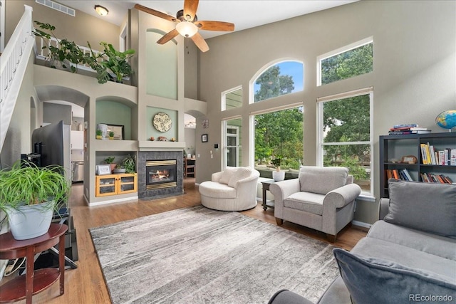 5370 S Gray St, Littleton, CO 80123 - living room featuring a towering ceiling, ceiling fan, wood finished floors, and a tile fireplace