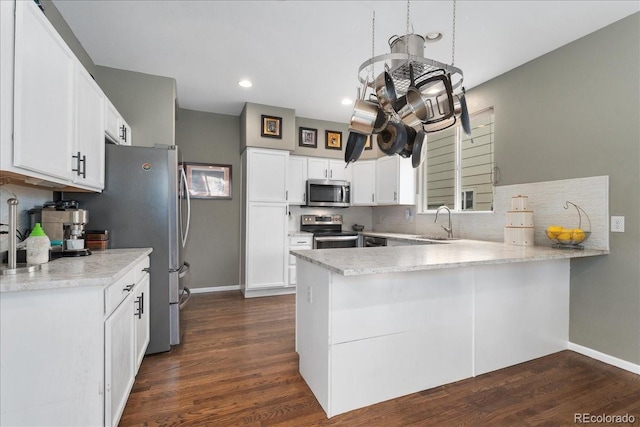5370 S Gray St, Littleton, CO 80123 - kitchen with appliances with stainless steel finishes, a peninsula, backsplash, dark wood finished floors, and recessed lighting