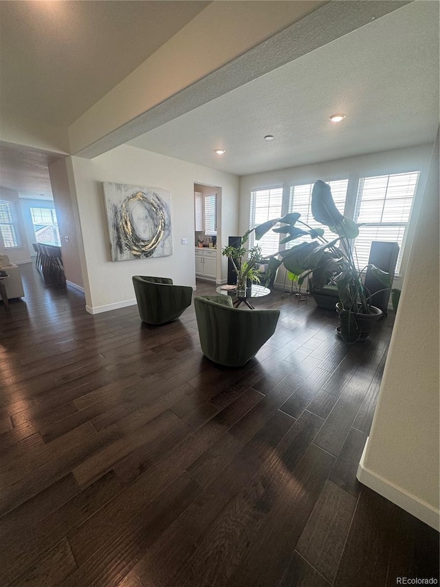 living area featuring dark wood-type flooring, baseboards, and recessed lighting