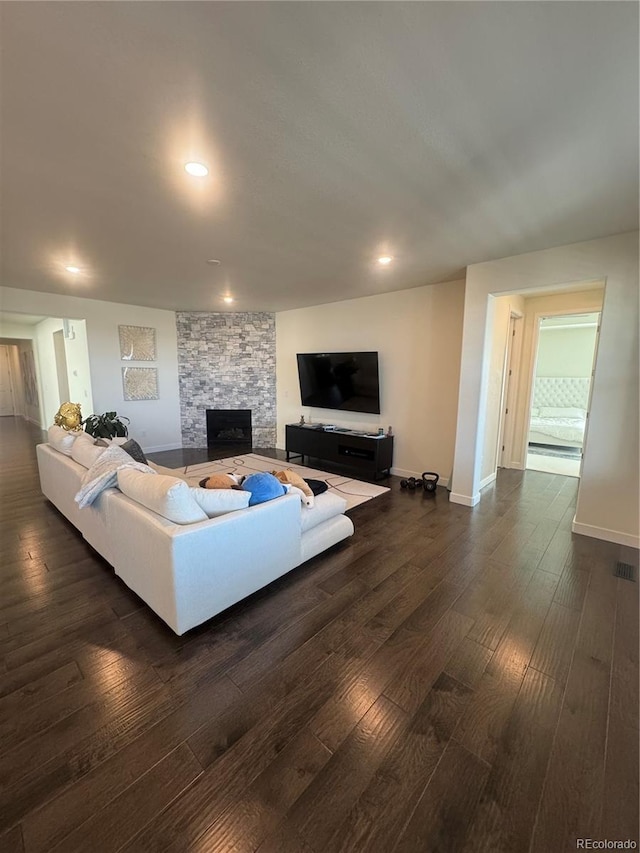 living area with dark wood-style floors, a fireplace, baseboards, and recessed lighting