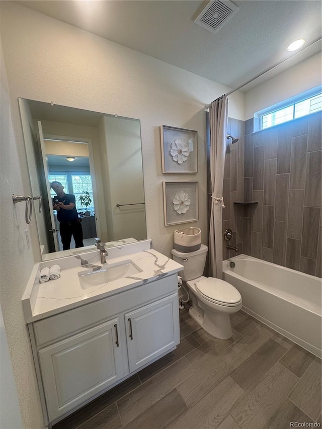 full bathroom with toilet, shower / bath combo with shower curtain, wood finished floors, and vanity