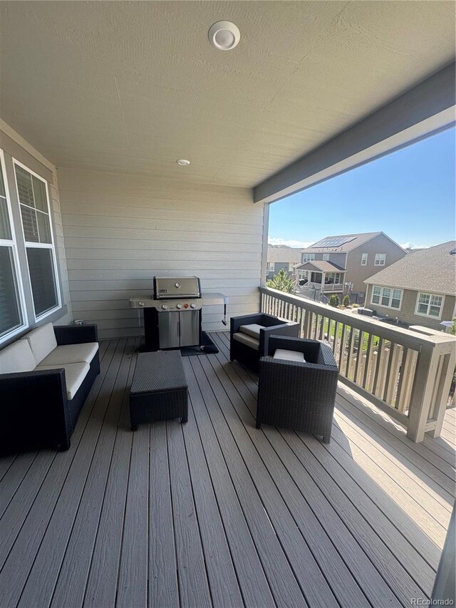 deck with a grill, an outdoor hangout area, and a residential view