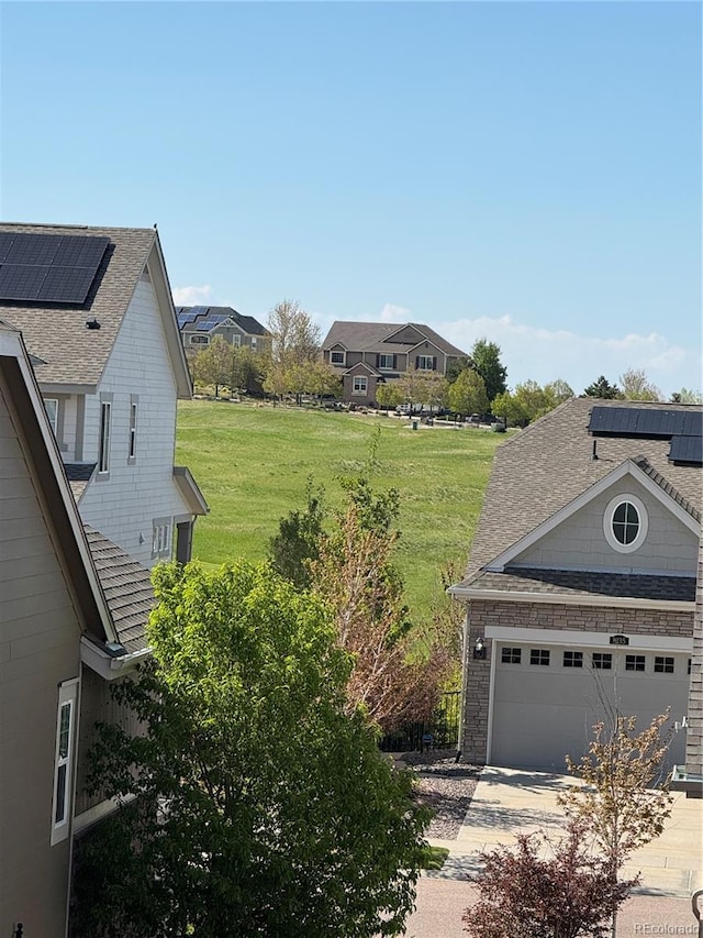 view of green lawn with concrete driveway