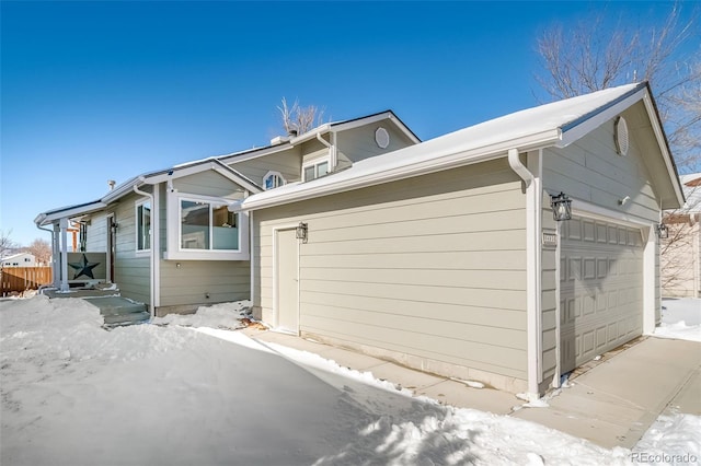 view of snowy exterior with a garage