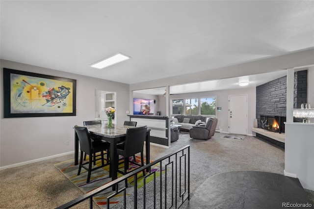 2633 Summit Dr, Colorado Springs, CO 80909 - carpeted dining room featuring a fireplace and baseboards
