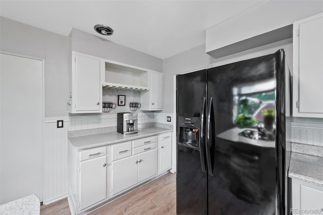 2633 Summit Dr, Colorado Springs, CO 80909 - kitchen featuring black fridge, light countertops, open shelves, white cabinetry, and light wood-type flooring