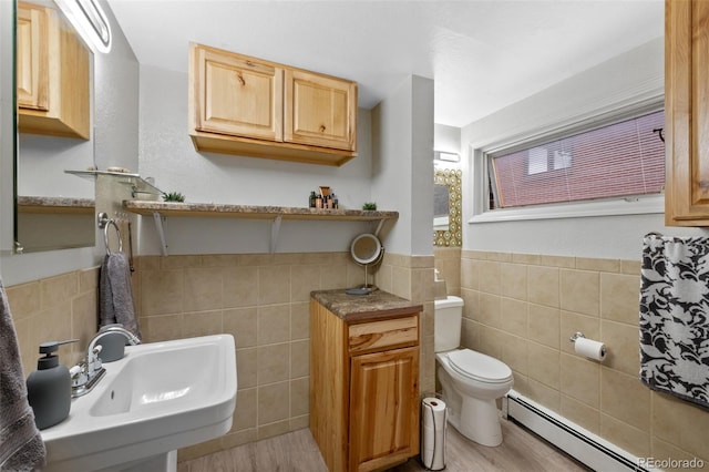2633 Summit Dr, Colorado Springs, CO 80909 - bathroom with tile walls, baseboard heating, a wainscoted wall, and wood finished floors